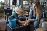 Frau zeigt zwei Kinder das Töpfern