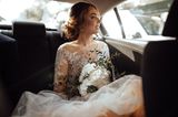 Braut sitzt im Auto auf dem Weg zum Altar