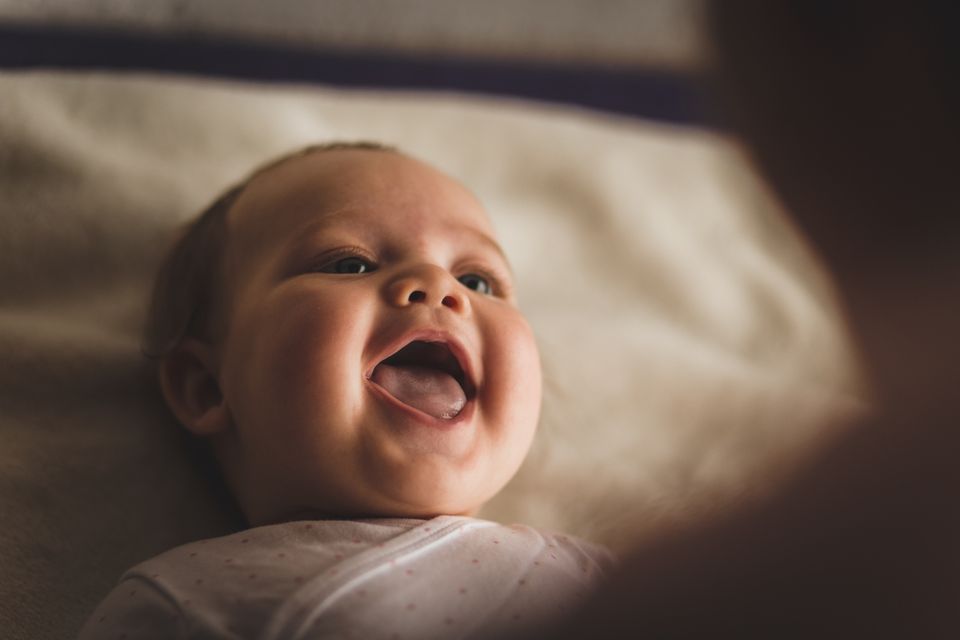 Baby lächelt mit offenem Mund