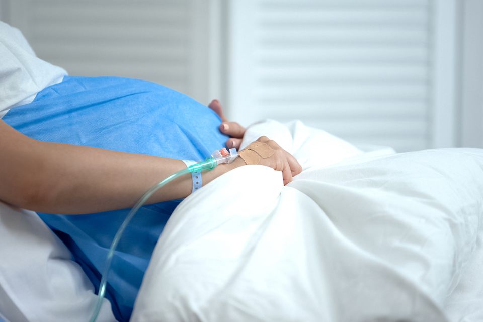 Schwangere im Bett mit Infusionszugang