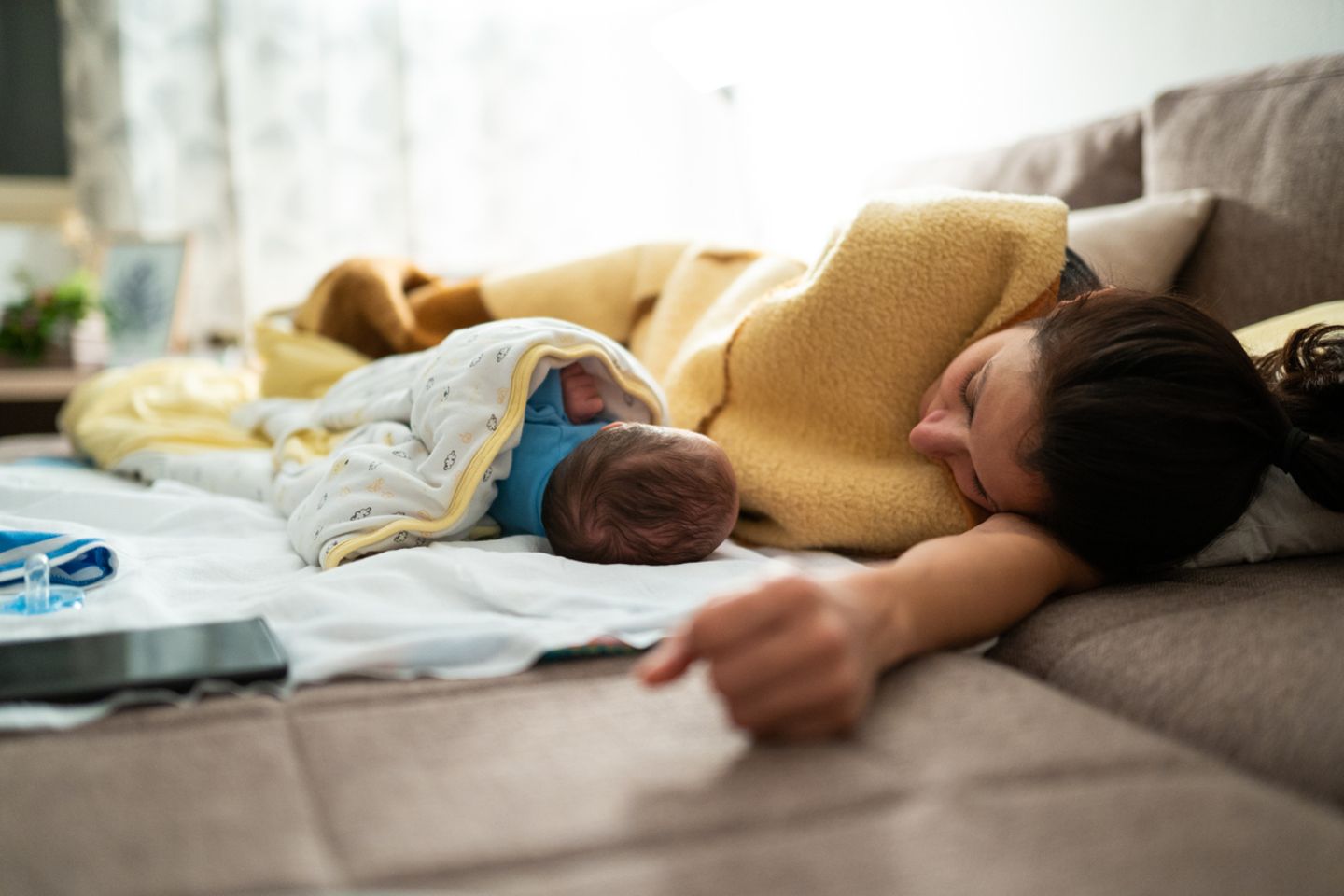 Baby und Mutter schlafen auf dem Sofa