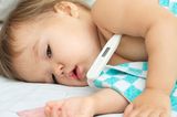 Fieber messen: Einem Baby steckt ein Fiebertermometer in der Achsel