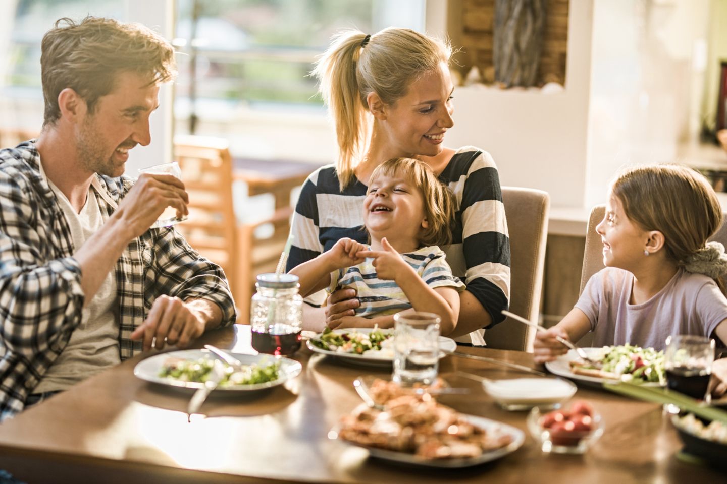 Eltern reden mit Kindern beim Essen über den Tag