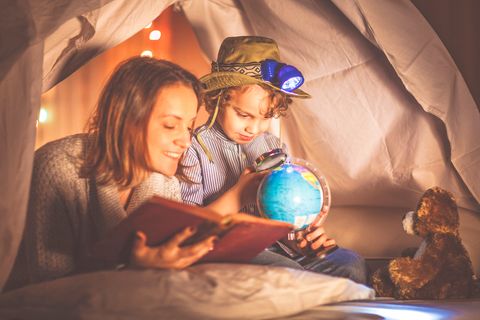 Mutter und Sohn im Indoor-Zelt mit Globus, Buch