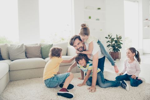 Vater und vier Kinder toben im Wohnzimmer