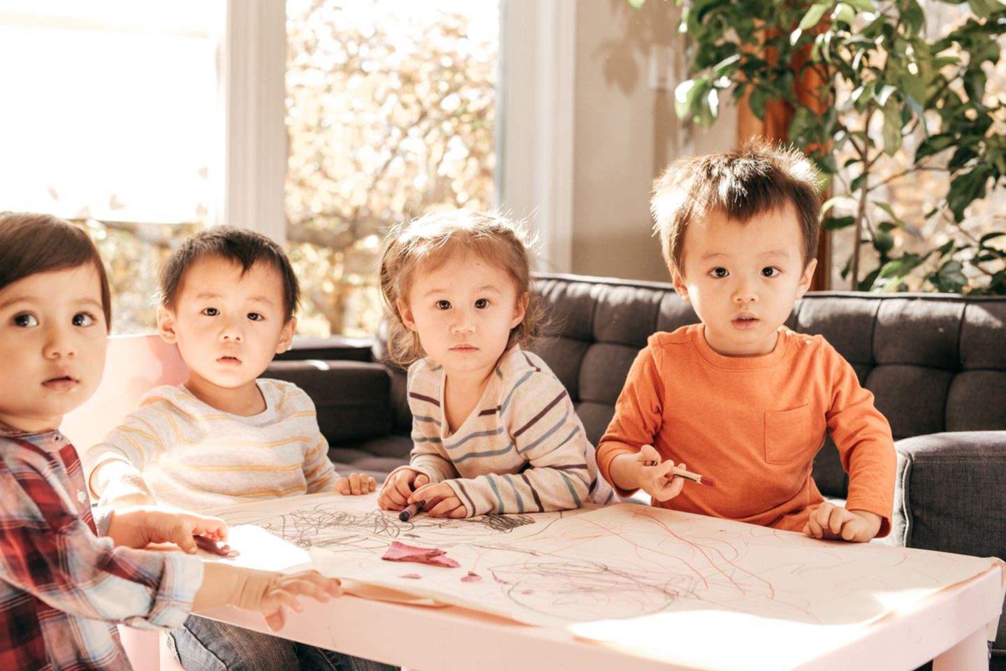 Vier Kleinkinder malen zusammen an einem Tisch