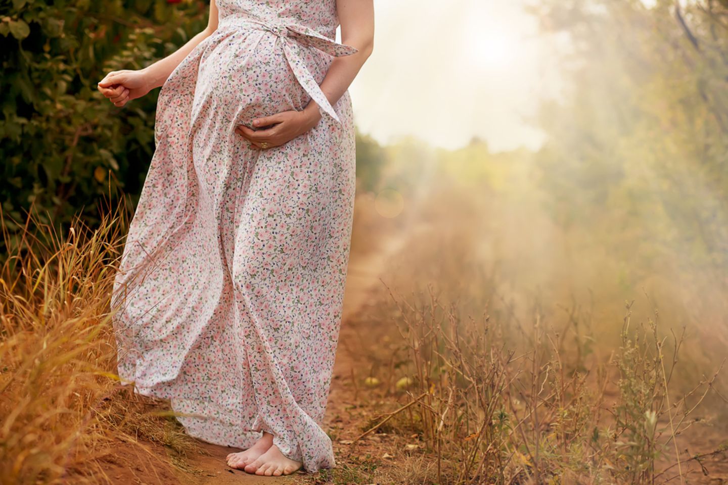 In der Schwangerschaft können auch Haare auf dem Bauch wachsen. Eine Schwangere geht draußen spazieren