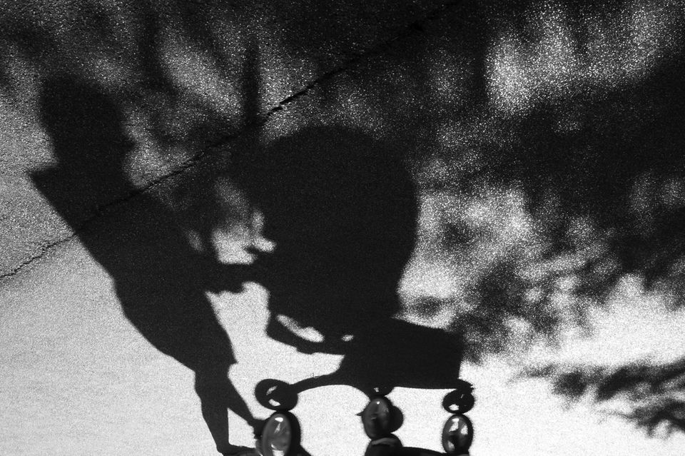 Schatten einer Mutter mit Kinderwagen