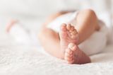 Baby Füße, während das Baby auf einer Matratze liegt
