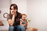 Vater ist müde, während Baby schreit