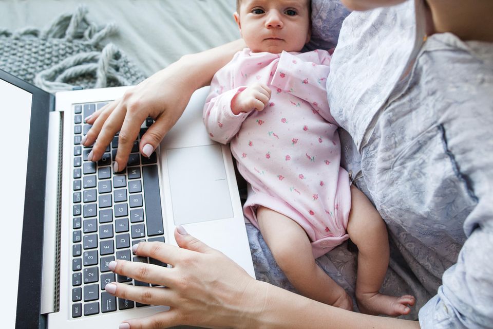 Baby im Schoß während Mutter arbeitet