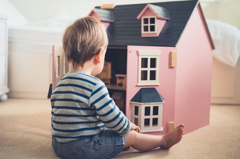 Rosa ist für alle da: Kind spielt mit Puppenhaus