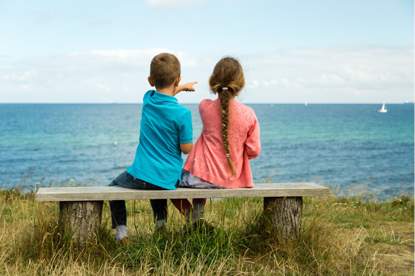 Nordische Namen: Mädchen und Junge auf einer Bank vor einem See.