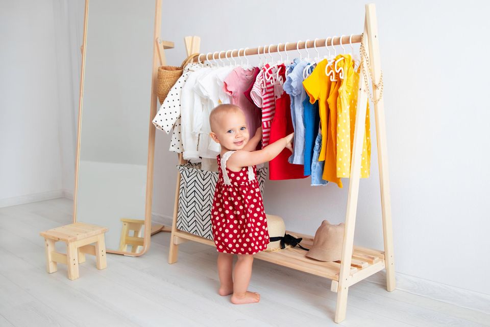 Baby steht vor ihrer Garderobe