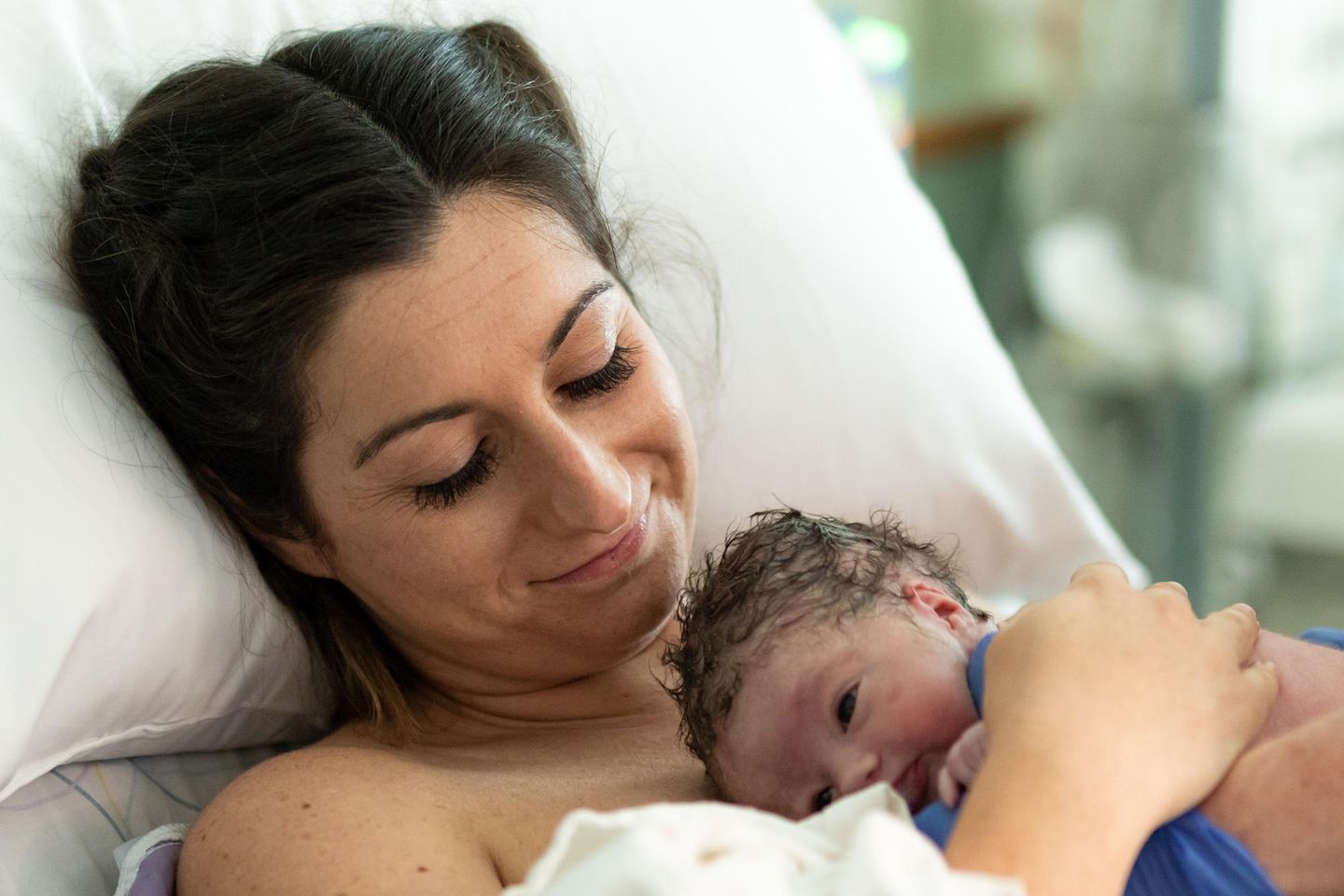 Mutter mit ihrem Neugeborenen im Krankenhausbett