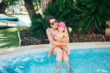 Mama und Baby im Schatten am Pool