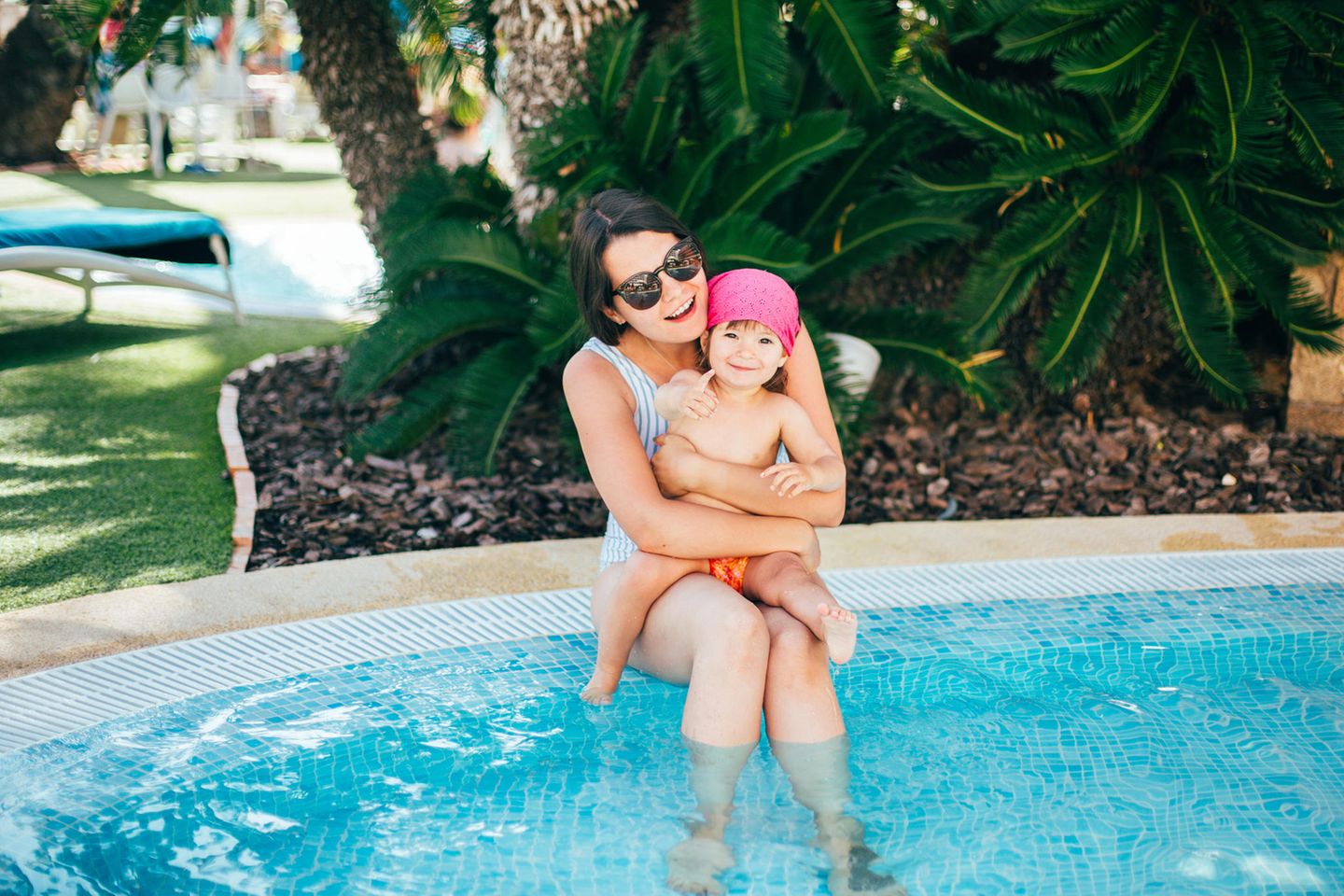 Mama und Baby im Schatten am Pool