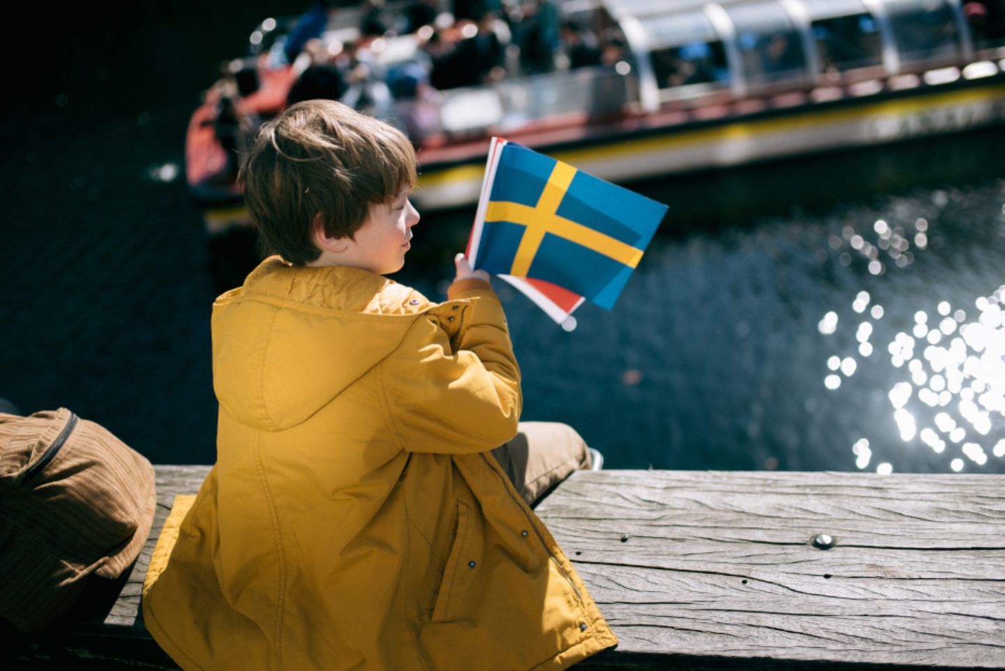 Nordische Jungennamen: Junge hält Schwedenflagge in der Hand.