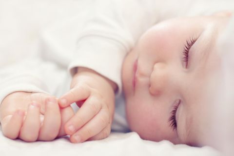 Babymatratze im Test: Friedlich schlafendes Baby in Weiß.