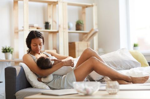 Ernährung in der Stillzeit: Frau mit Baby im Wohnzimmer