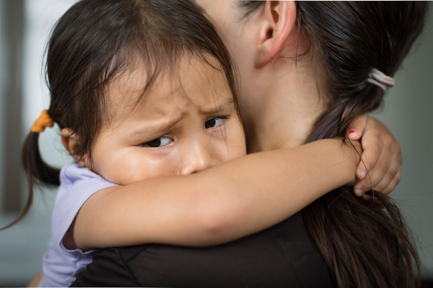 Kleines trauriges Mädchen umarmt seine Mutter