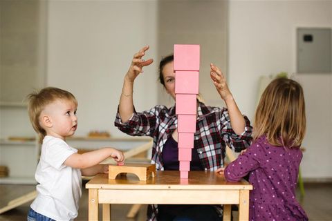 Sichere Kita: Zwei Kinder spielen mit ihrer Betreuerin