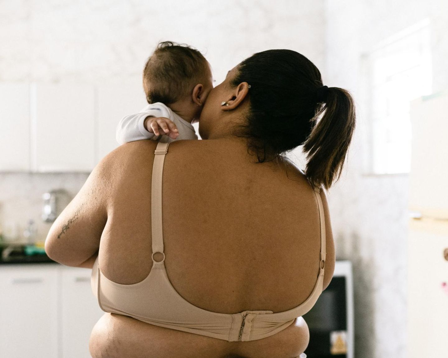 Postpartum Unfiltered: Mutter hält Baby auf  dem Arm