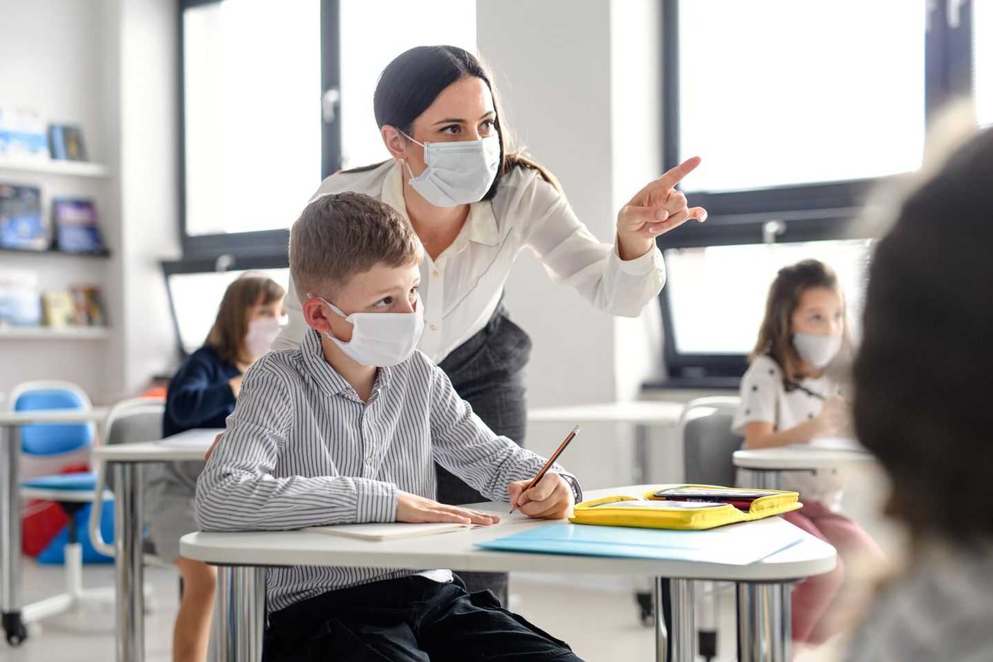 Impffrage: Lehrerin erklärt Schüler etwas