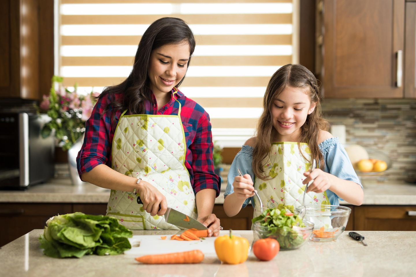 Mutter und Tochter in Küche schneiden Gemüse