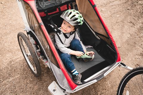 Kinderfahrradanhänger im Test: Junge mit Helm sitzt im Fahrradanhänger