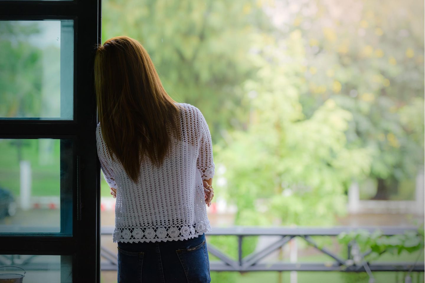 Mit diesen 7 Dingen machst du dir das Leben schwer: Frau schaut nachdenklich aus dem Fenster.