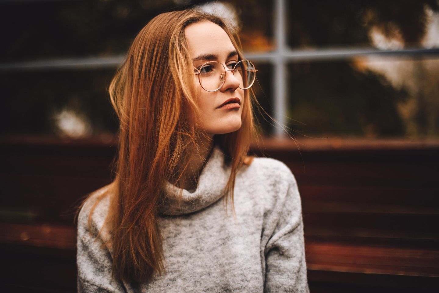 Diese 5 Gedanken helfen dir gegen das Gefühl, nicht gut genug zu sein: Frau mit langen Haaren und Brille schaut ernst.
