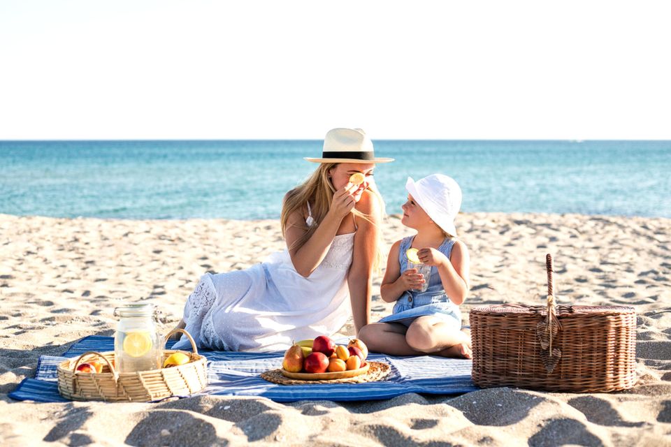 Umweltfreundlich: Mutter mit Tochter am isst am Strand
