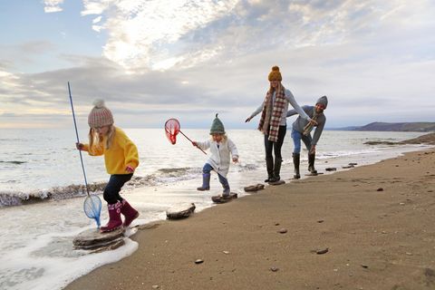 Umweltfreundlich: Familie am Strand mit Kescher in der Hand