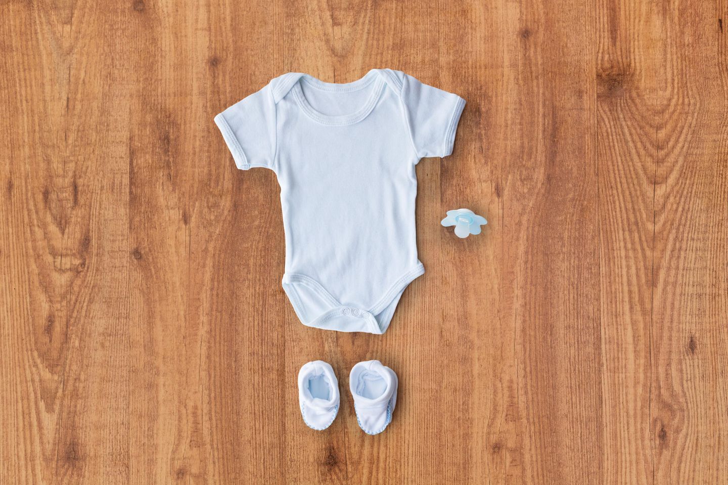 Nachhaltige Kleidung: Babyoutfit liegt auf einem Holztisch