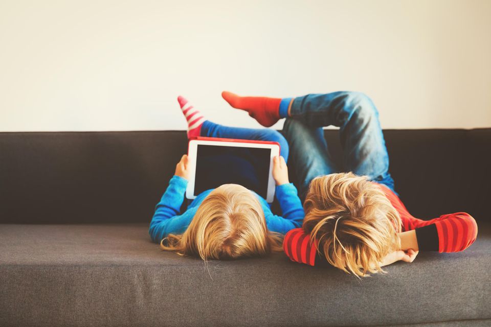 Kinder-Tablet im Test: Kinder Kinder auf dem Sofa schauen aufs Tablet.