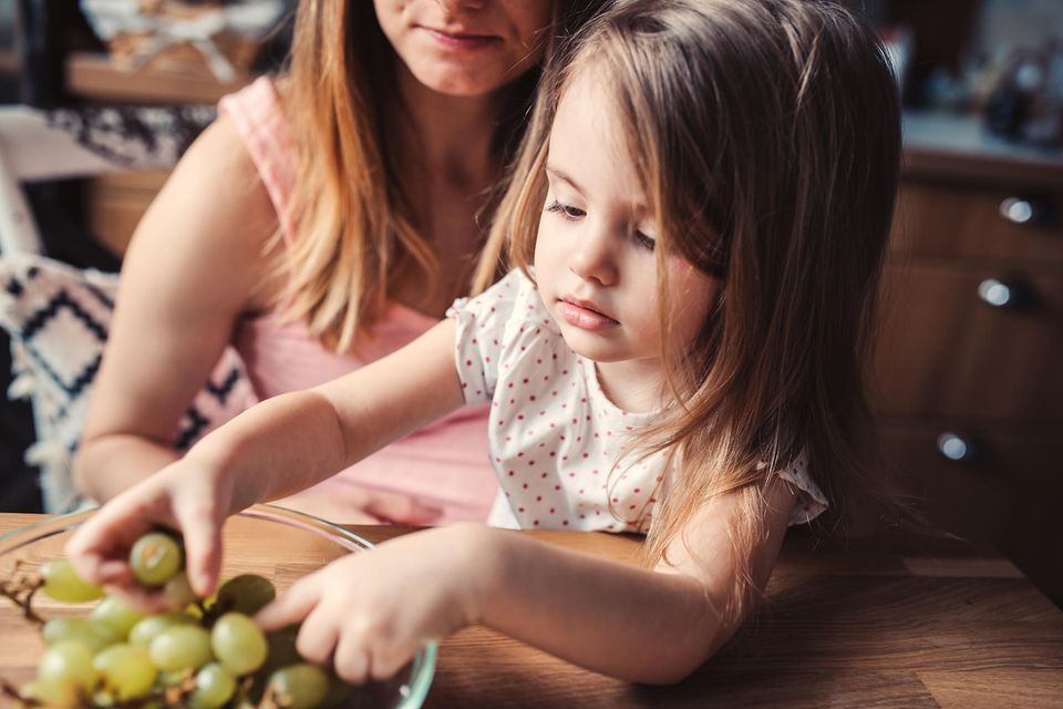 Versteckter Zucker: Diese 6 Lebensmittel sind heimliche Zuckerfallen | Mutter und Tochter essen Weintrauben.
