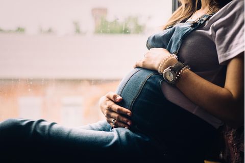 Schwanger sein in 3 worten: Frau hält sich den Babybauch
