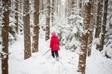 Mädchen läuft durch verschneiten Wald