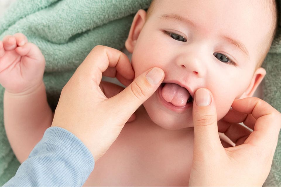 Ein Baby bekommt eine Babymassage im Gesicht