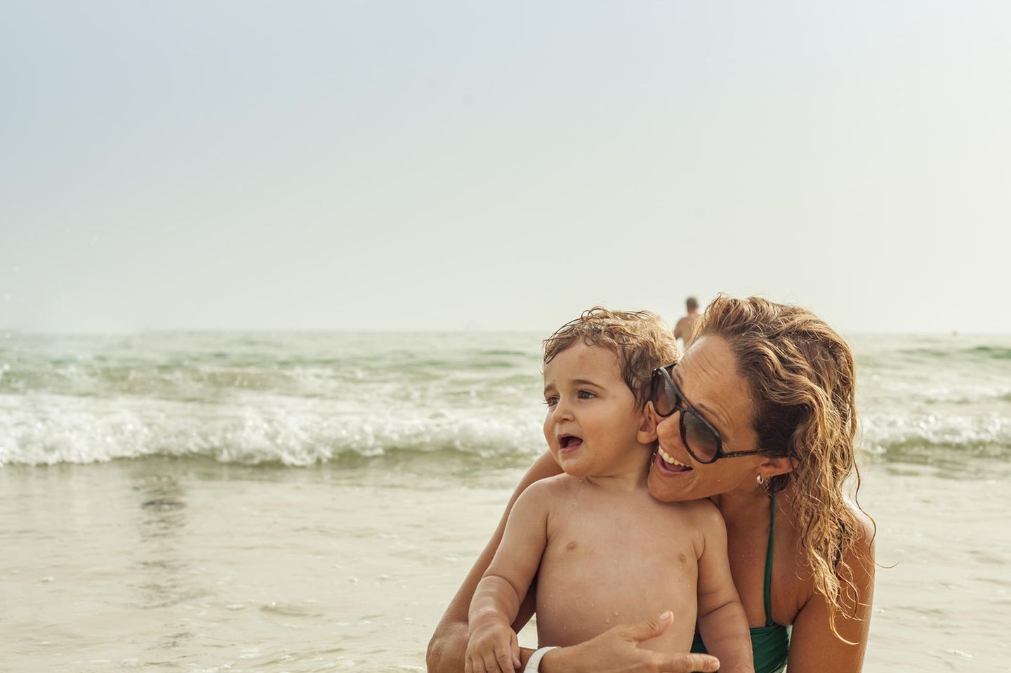 Mutter und Sohn am Strand in Spanien