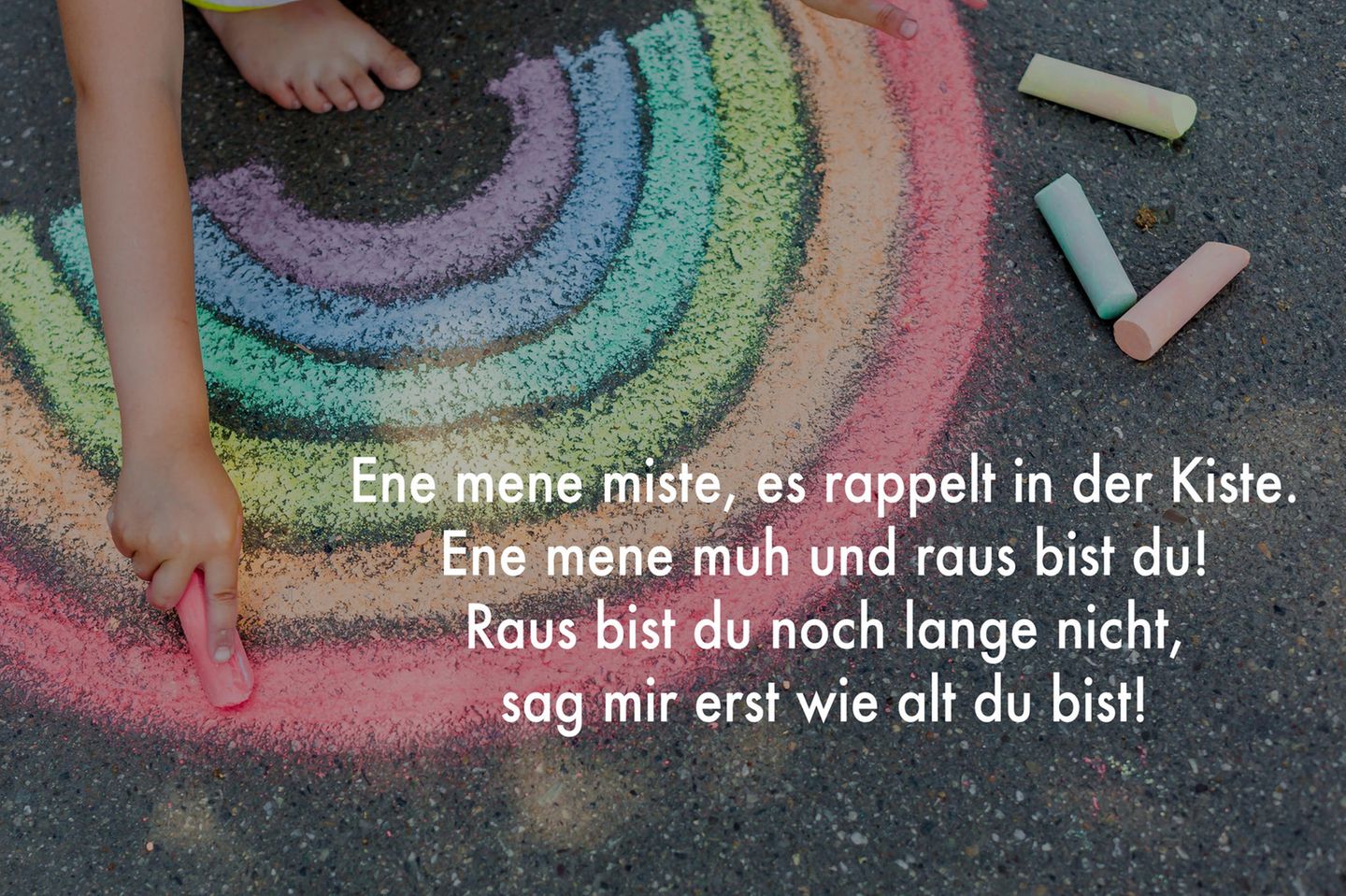 Ein Kinderreim ist auf einer Grafik zu lesen, auf der ein mit Kreide gemalter Regenbogen zu sehen ist.