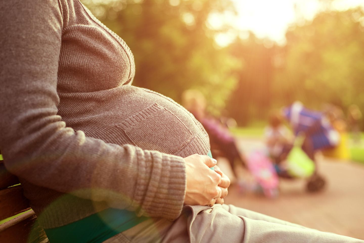 Negative Seiten in der Schwangerschaft: Schwangere sitzt auf Bank