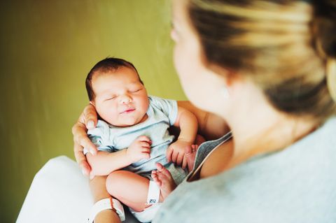 Geburtskomplikationen: eine Frau hält ein neugeborenes Baby in den Armen