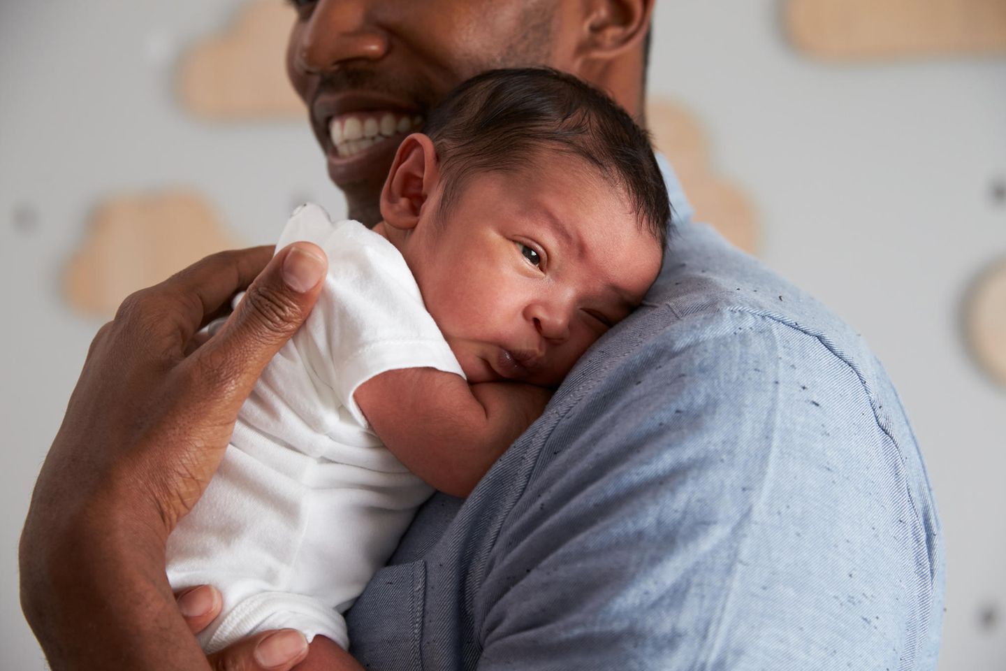 Frisch geschlüpft: Junger Vater hält ein neugeborenes Baby auf dem Arm