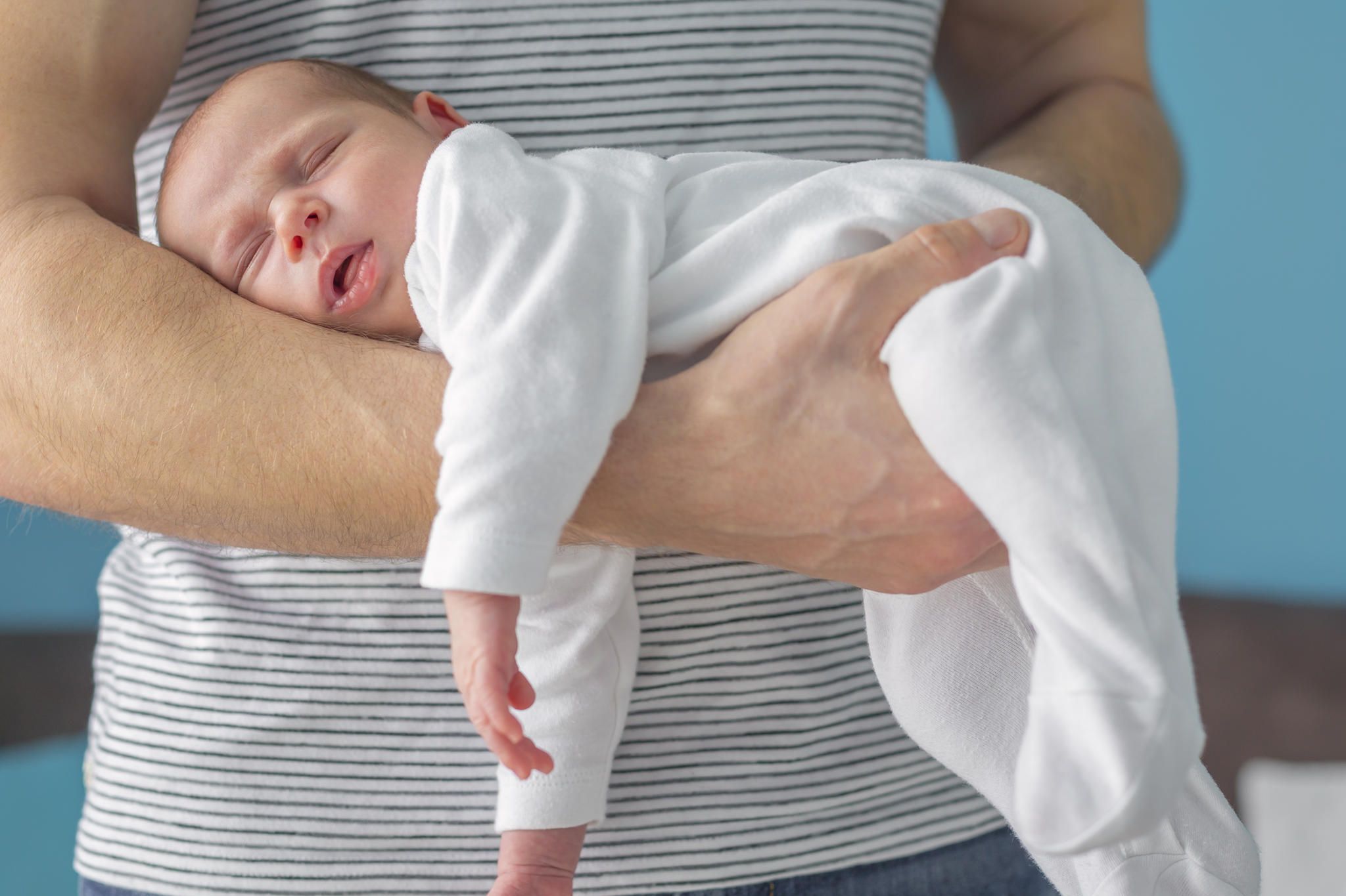 Ребенок лежит на животе. Выкладывать ребенка на живот. Поза для малыша при коликах. Младенческие колики. Рука младенца в животе.