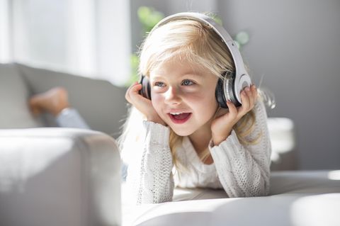 Toniebox Alternative: Ein Mädchen hört Hörspiel über Kopfhörer