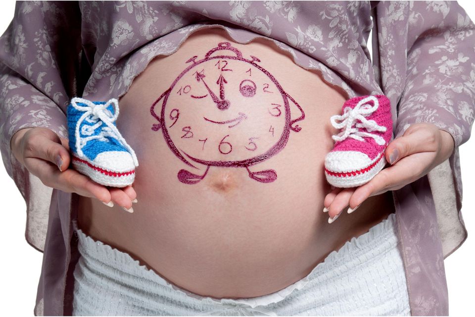 Babybauch bemalen: Uhr aufgemalt auf Babybauch