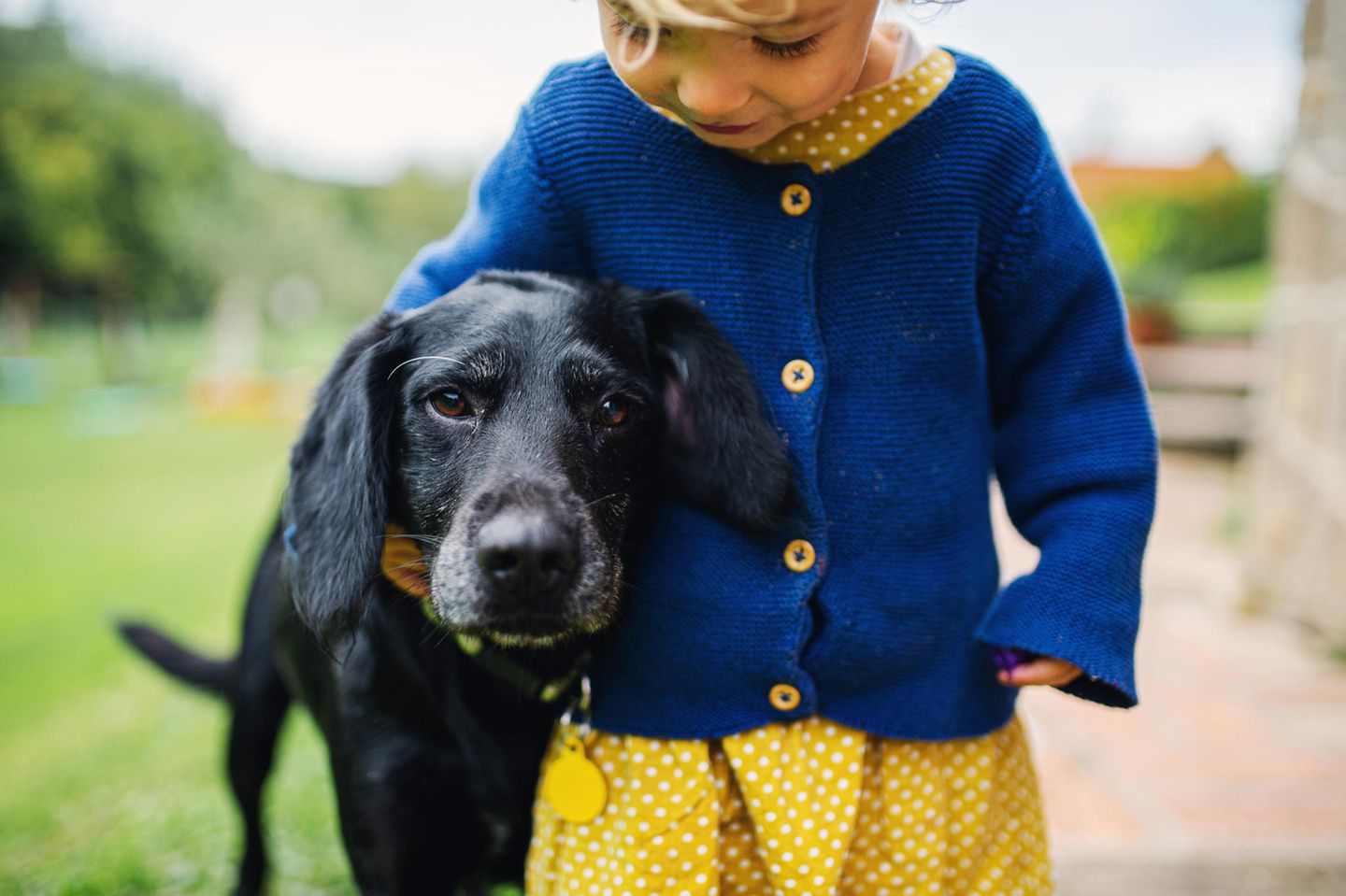 Uli Bliffert: ein kleiner blonder Junge steht neben einem schwarzen Hund