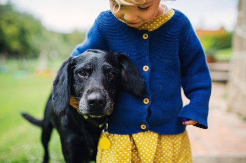 Uli Bliffert: ein kleiner blonder Junge steht neben einem schwarzen Hund